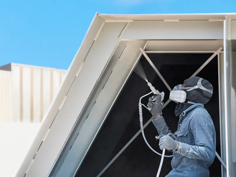 Technician applies encapsulant to fiberglass liner inside an air handler